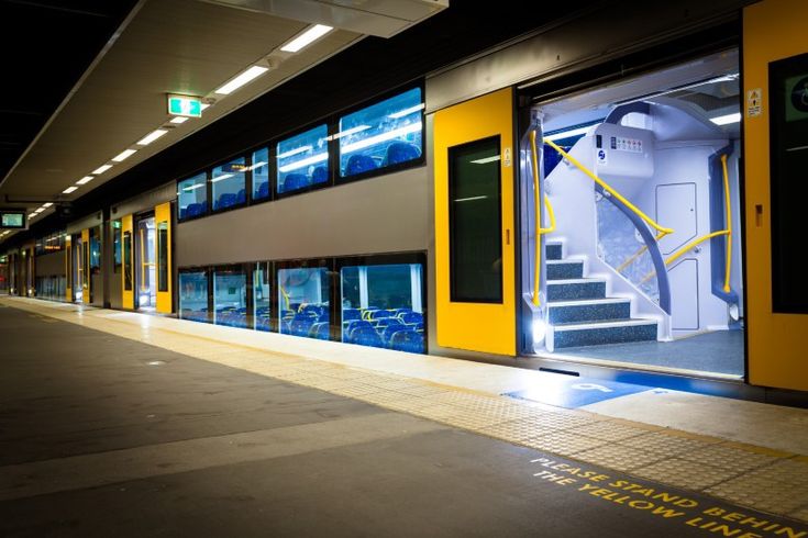 an empty train station at night with its doors open and the stairs leading up to it