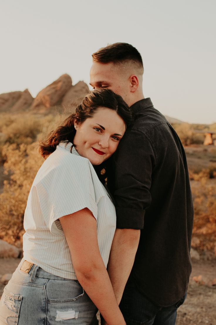 a man and woman standing next to each other in the desert