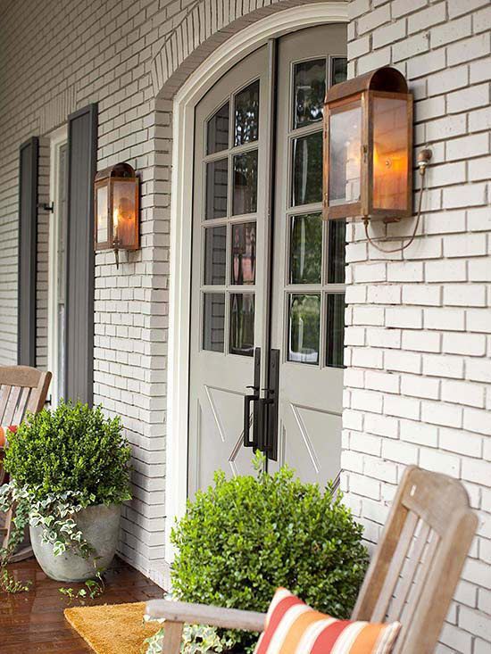 a porch with chairs and potted plants on it