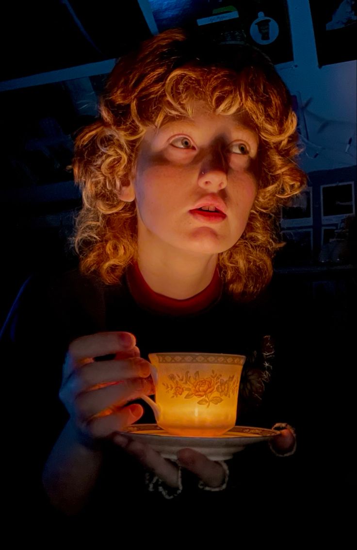 a woman holding a lit candle in her hands