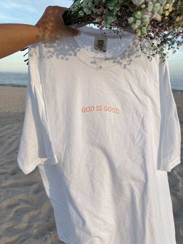 Introducing our Women's Boyfriend Tee, a perfect blend of dainty and trendy fashion with a faith-based touch. This relaxed-fit tee is designed for both comfort and style, crafted from soft, high-quality fabric. The front features a delicate, dainty embroidery of the phrase "God is Good," adding a subtle yet meaningful accent. Its versatile design makes it easy to pair with jeans, shorts, or skirts for a chic, casual look. Embrace your faith and style with this cute and trendy tee, a must-have ad Inspirational Relaxed Fit T-shirt For Spring, Inspirational White T-shirt For Everyday, Inspirational Letter Print T-shirt For Spring, White T-shirt With Embroidered Text For Summer, Inspirational Pink Cotton T-shirt, White Inspirational Relaxed Fit T-shirt, Summer Relaxed Fit T-shirt With Embroidered Text, Inspirational Cotton Tops For Summer, Inspirational Cotton Summer Tops