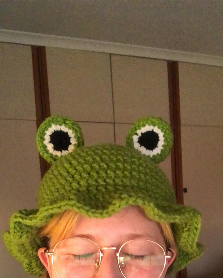 a woman with glasses and a knitted frog hat