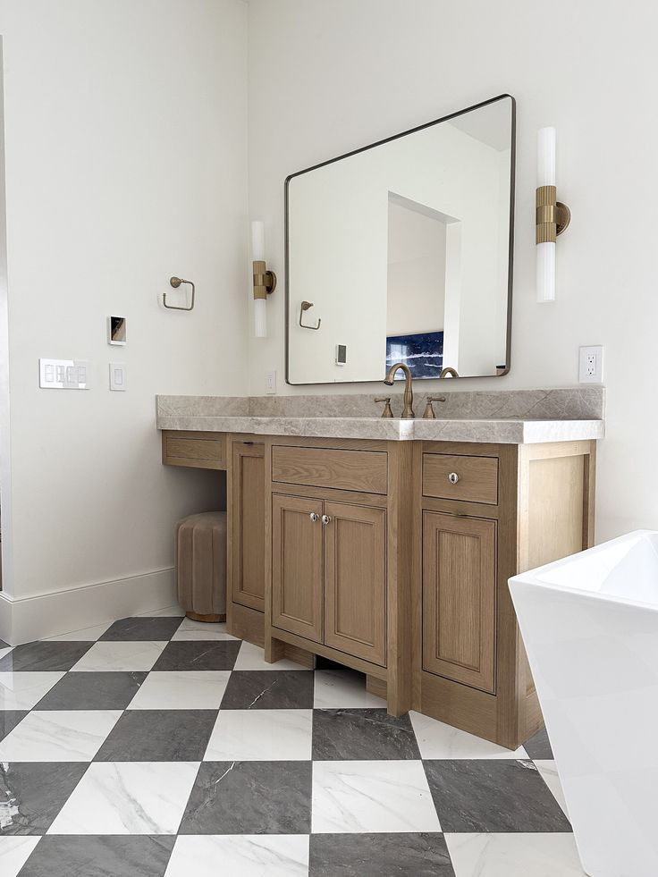 a bathroom with a checkered floor and large mirror