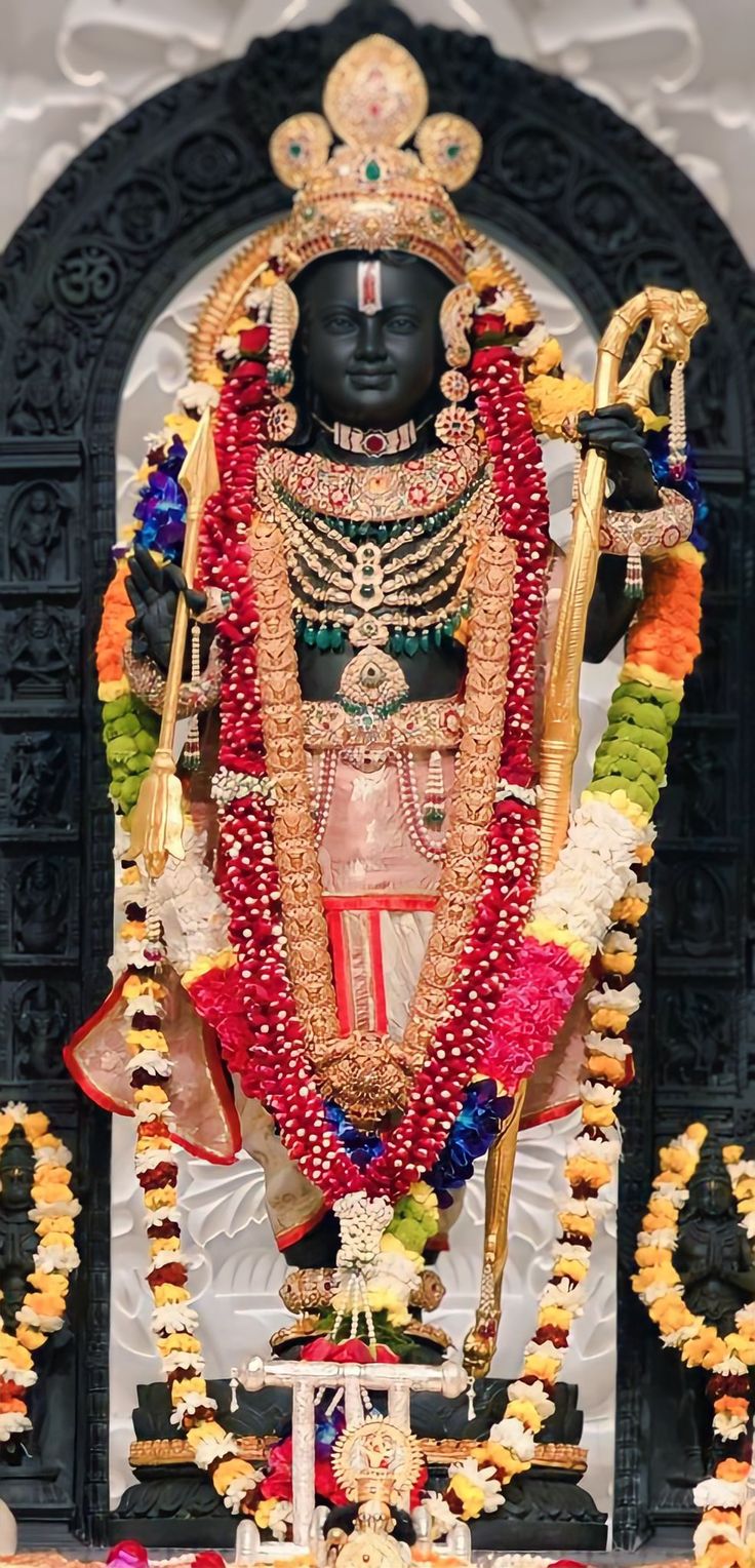 the statue is decorated with flowers and garlands