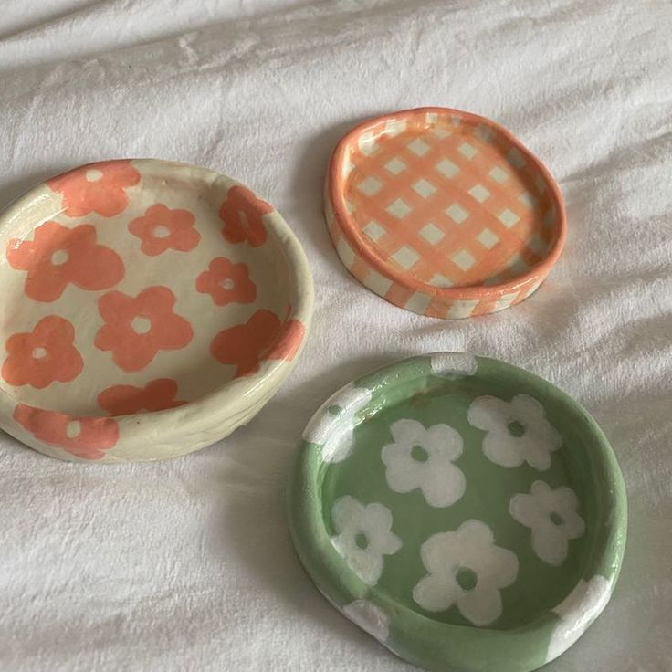 three small dishes sitting on top of a bed