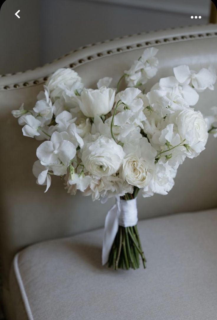 a bouquet of white flowers sitting on top of a chair