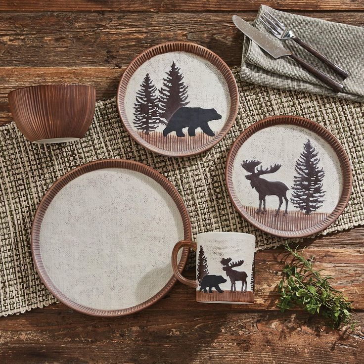 three plates with moose and pine trees on them