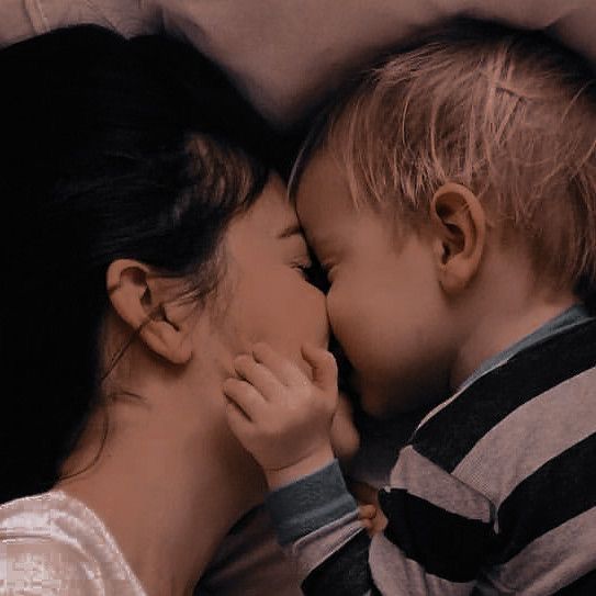 a woman kissing a small child on the cheek