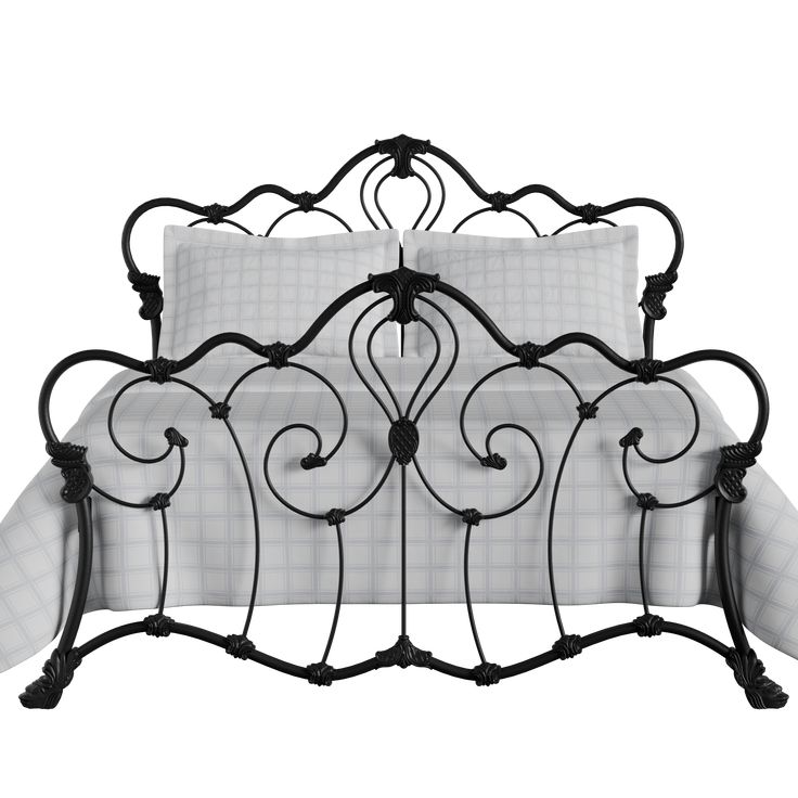 an iron bed frame with white sheets and black wrought designs on the headboard, along with two pillows