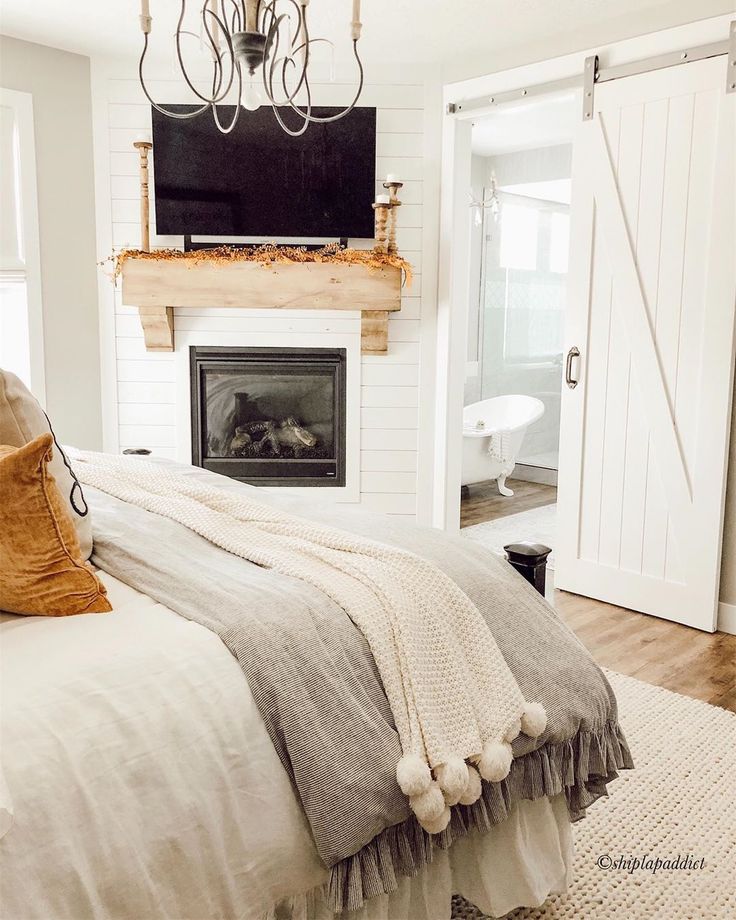 a bedroom with a fireplace, bed and white walls in it's centerpiece