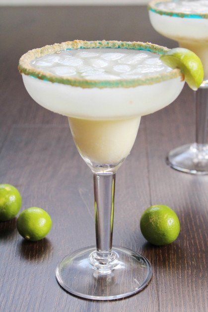 two margaritas sitting on top of a wooden table