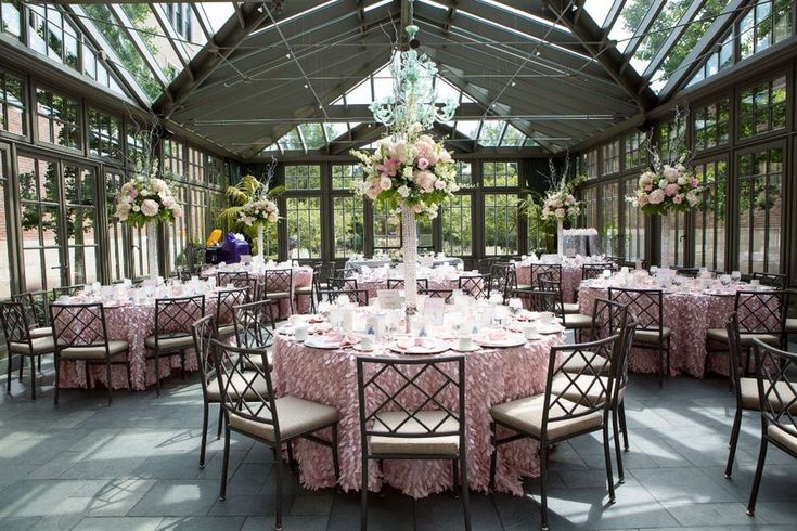 a dining room with tables and chairs covered in pink tablecloths, flowers and centerpieces