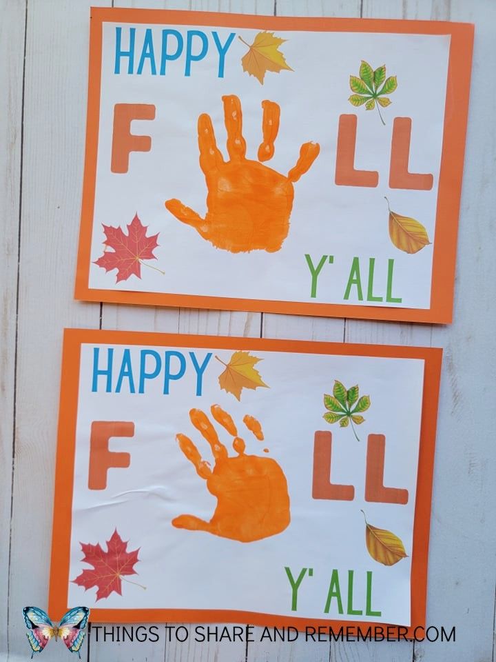 two handprints are displayed on the side of a white wall with orange and green leaves