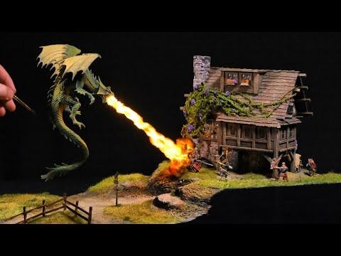 a miniature house on fire with a dragon attacking it