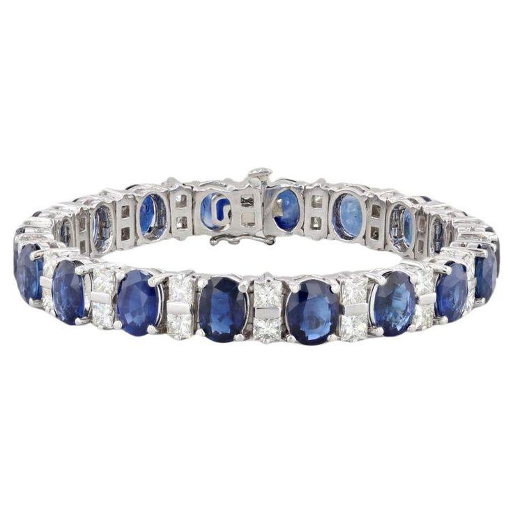 This stunning custom bracelet is set with deep blue oval sapphires accented by VS2 princess diamonds, creating a lovely white and blue contrast along a polished platinum chain. This statement piece displays the highest craftsmanship and comes with a GIA certificate for the sapphires as well as with an inner black velveteen box and outer white box. Gemstone Information: - Natural Sapphires - Total Carats - 29ctw Cut - Oval Brilliant Color - Blue Treatment - Heated GIA#: 1226436814 Geographic Orig Blue Sapphire Bracelet, Platinum Chain, Gia Certificate, Ceylon Blue Sapphire, Custom Bracelet, Sapphire Bracelet, Princess Diamond, Tennis Bracelet Diamond, White Box