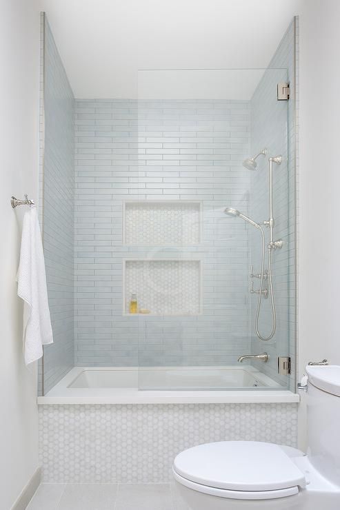 a bathroom with a toilet, bathtub and shower stall in white tiled flooring