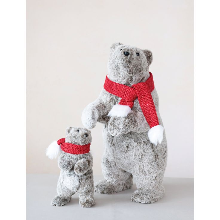 a stuffed bear and its baby are wearing red scarfs while standing next to each other