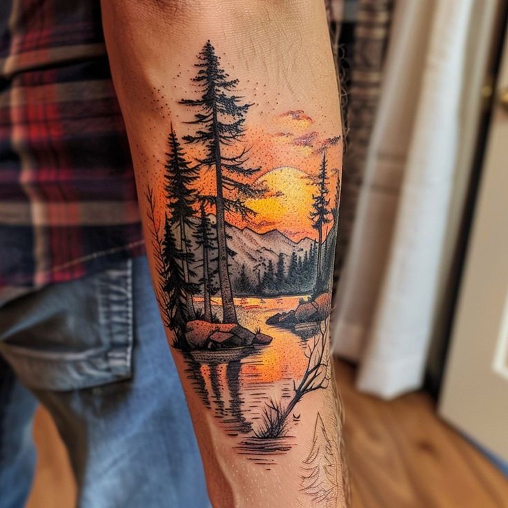 a man's arm with a sunset and trees tattoo on it