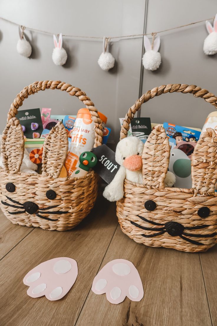 two baskets filled with toys sitting on top of a wooden floor next to bunnies