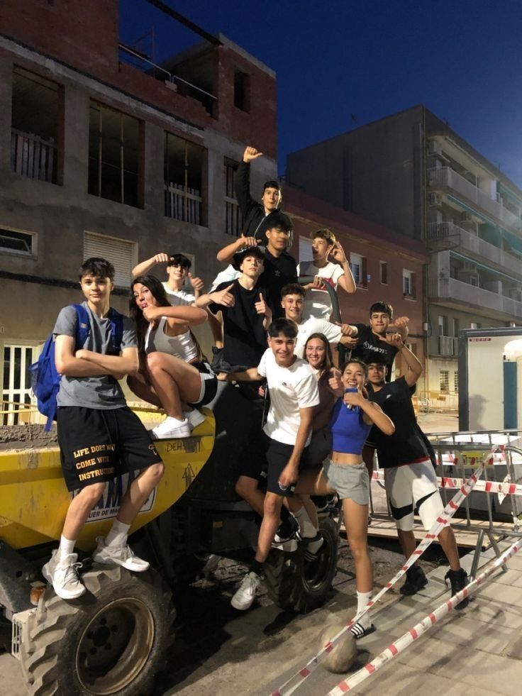 a group of people standing on the back of a truck in front of a building