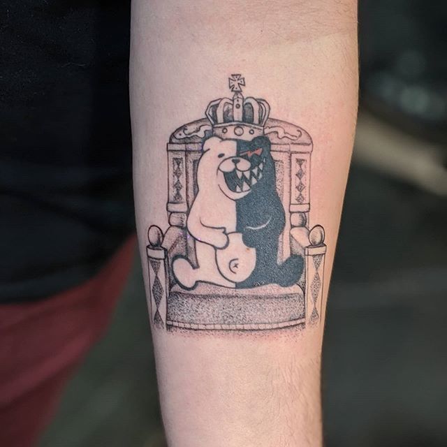 a tattoo on the arm of a man with a bear and crown in front of him