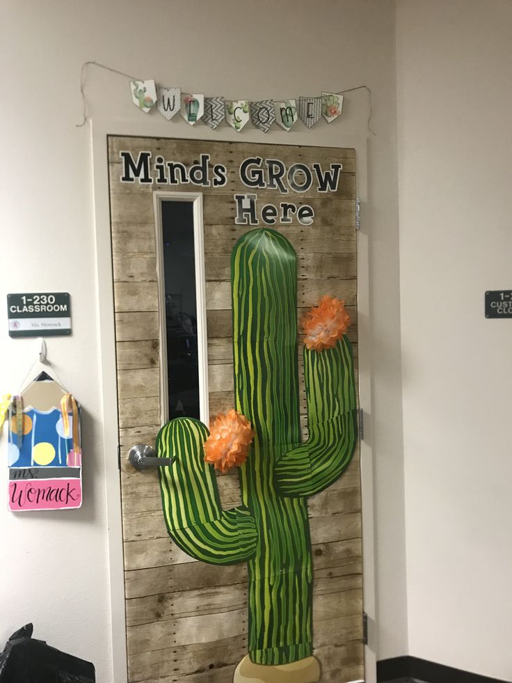 a large cactus plant sitting in front of a door with the words minds grow here on it