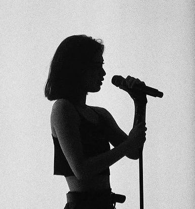 a woman holding a microphone in front of a white background