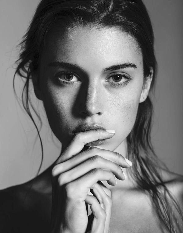 a young woman with freckled hair and blue eyes poses for a photo shoot