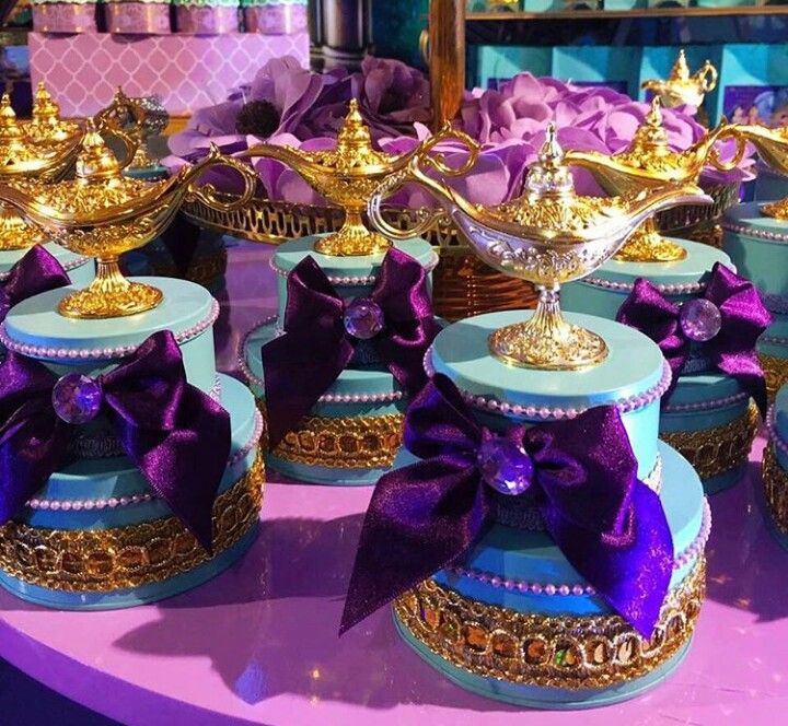 there are many blue and gold dishes with purple bows on them