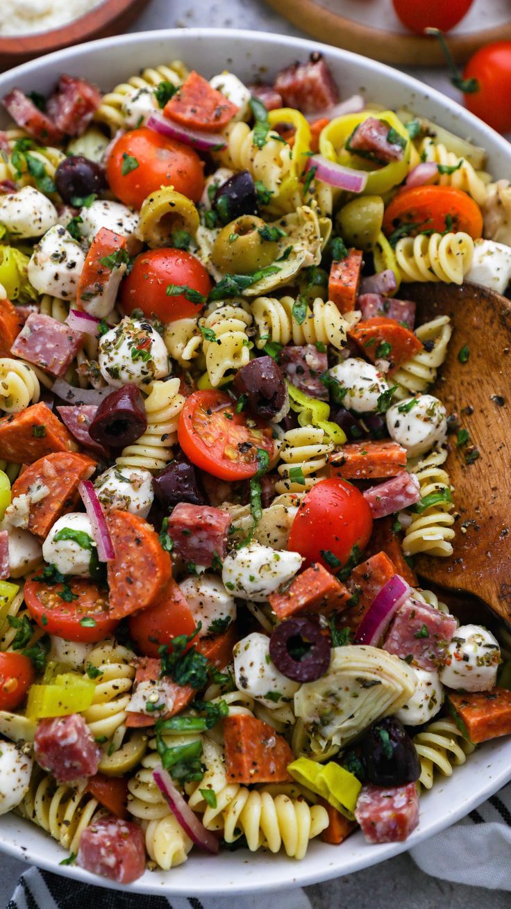 pasta salad with tomatoes, olives, mozzarella and parmesan cheese