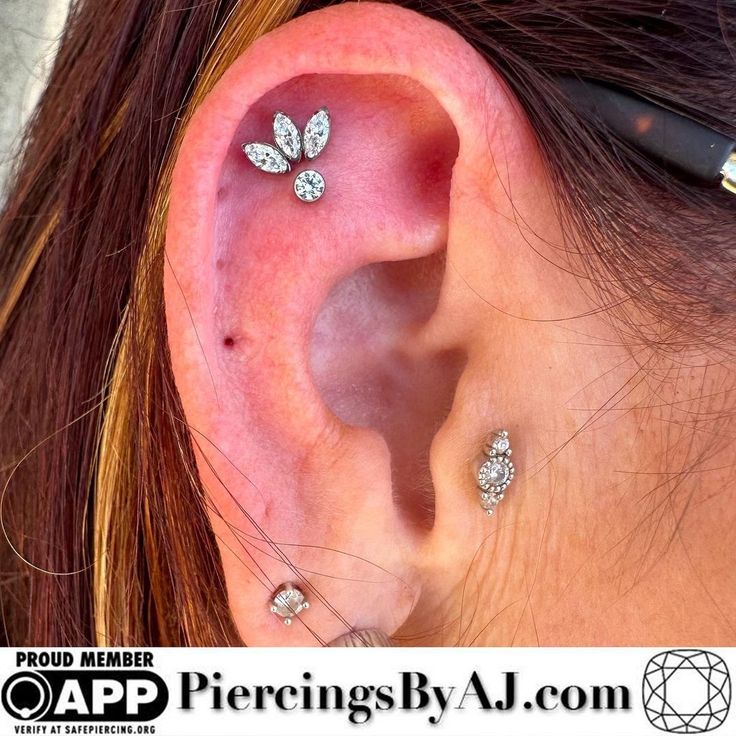 a woman's ear with three small diamonds on it