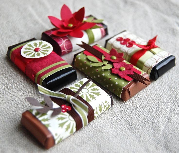 several wrapped gift boxes on a bed with red bows and poinsettia decorations