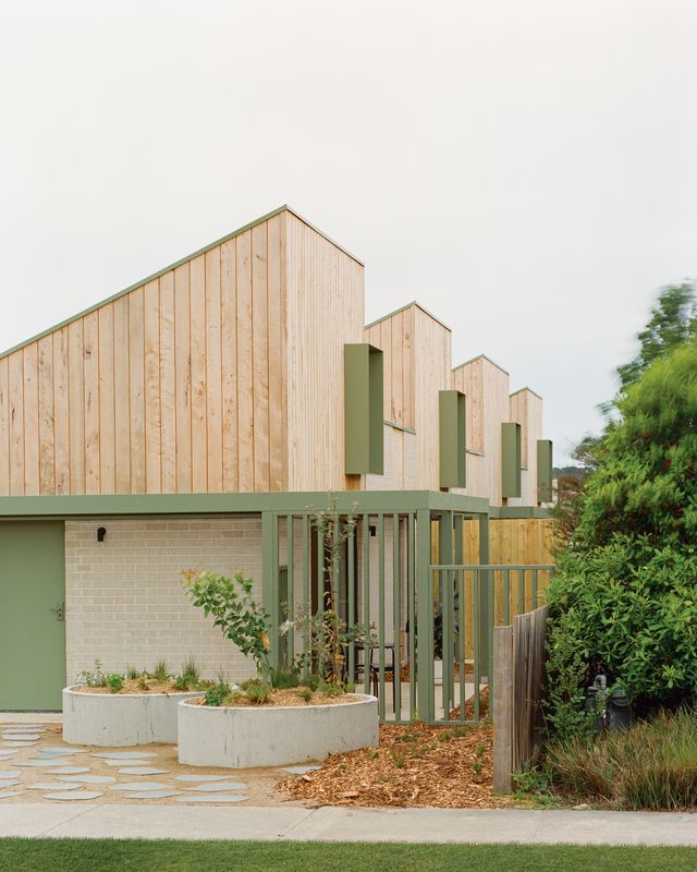 the building is made out of wood and has green shutters on it's sides