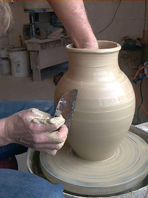 a person making a vase on a pottery wheel