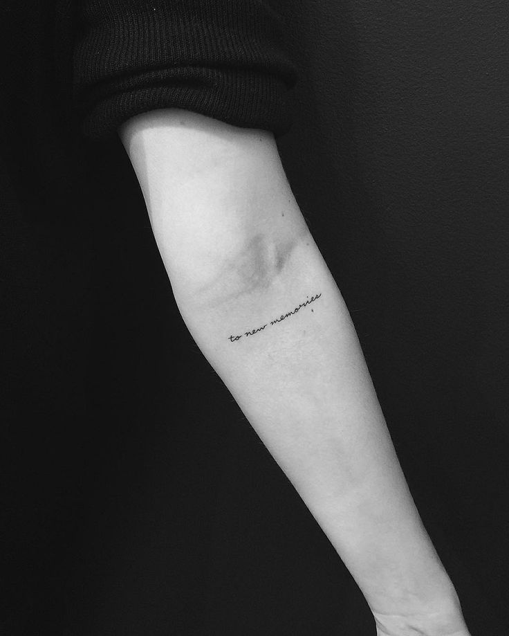 a person's arm with a quote tattooed on the left side of their arm