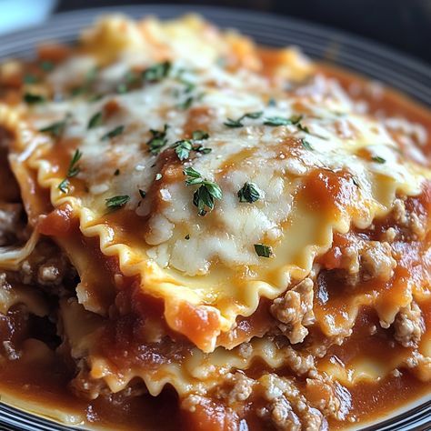 a close up of a plate of food with meat and cheese on it, including pasta