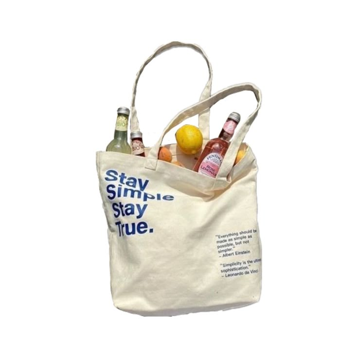 a tote bag filled with bottles of alcohol sitting on top of a white surface