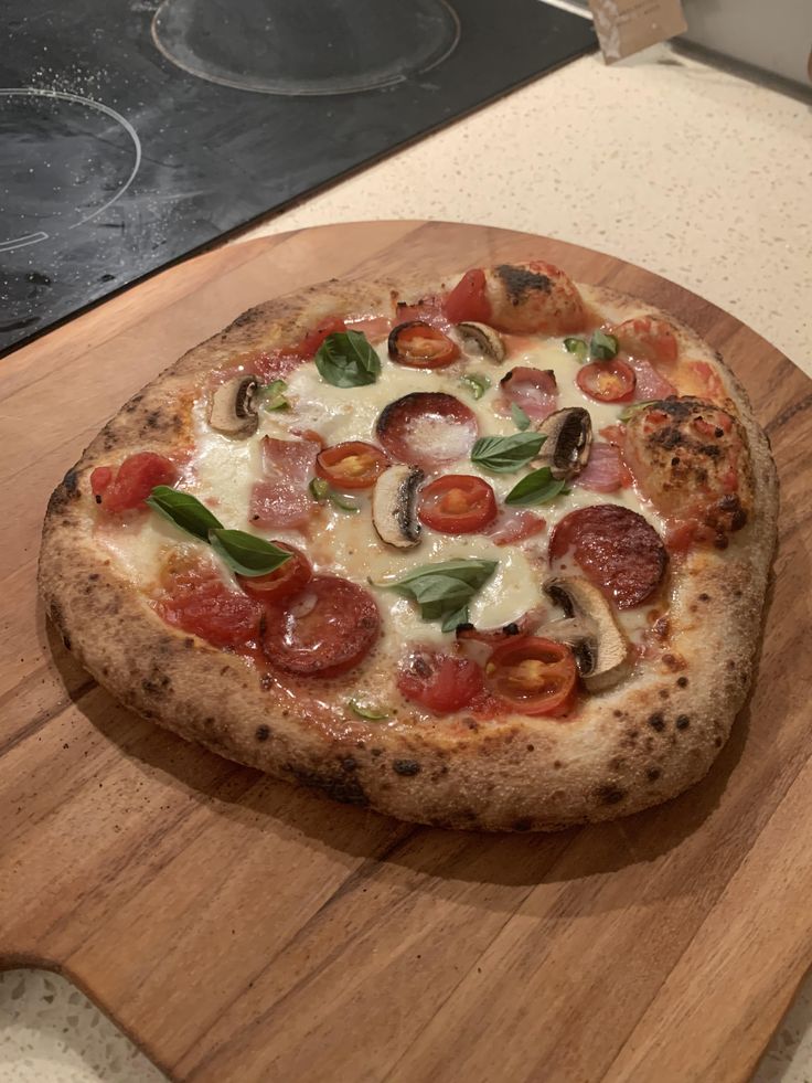 a pizza sitting on top of a wooden cutting board