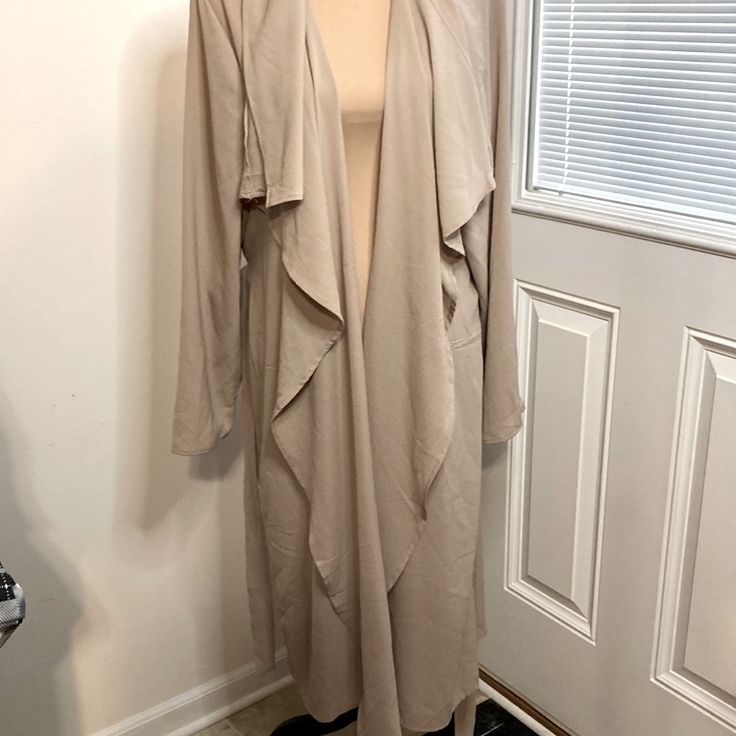 This Belted Jacket Is A Beautiful Khaki Color With A Wavy Collar And Lightweight Feel. It’s Texture Is Like Gauze, It’s Perfect For Just A Little Hint Of Chill In The Air And With Layers You Can Do Wonders With This Piece. It’s A Staple For Every Closet And Matches Almost Everything. It’s New With Tags Just A Little Too Small For Me. I Have A Smoke Free Home. Solid Open Front Outerwear For Work, Beige Open Front Layering Outerwear, Beige Long Coat Cardigan For Spring, Long Outerwear For Fall Day Out, Long Solid Color Outerwear For Daywear, Casual Open Front Outerwear For Daywear, Fitted Long Sleeve Outerwear For Day Out, Beige Open Front Outerwear With Pockets, Spring Oversized Open Front Outerwear