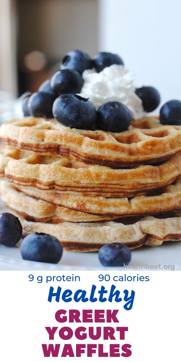 a stack of waffles with blueberries and whipped cream sitting on top of it