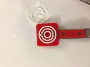 a pair of scissors and a red case with a white target on the inside of it