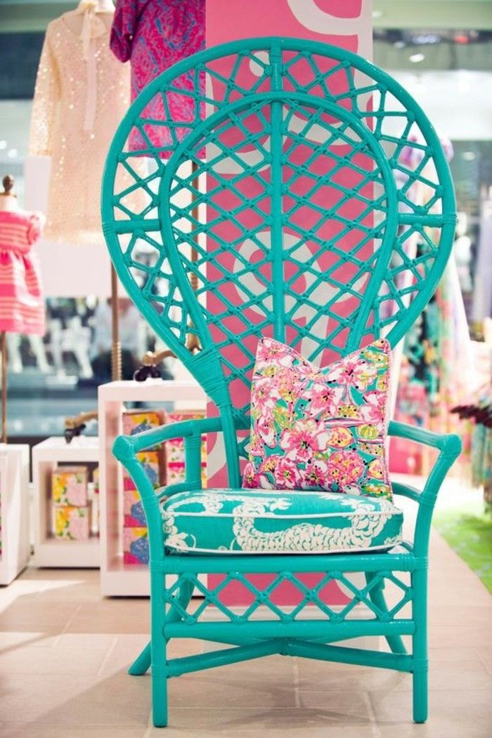 a blue chair sitting on top of a tile floor next to a pink and white sign