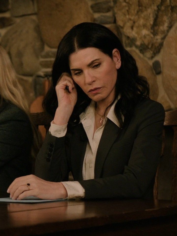 a woman sitting at a table talking on her cell phone and looking to the side