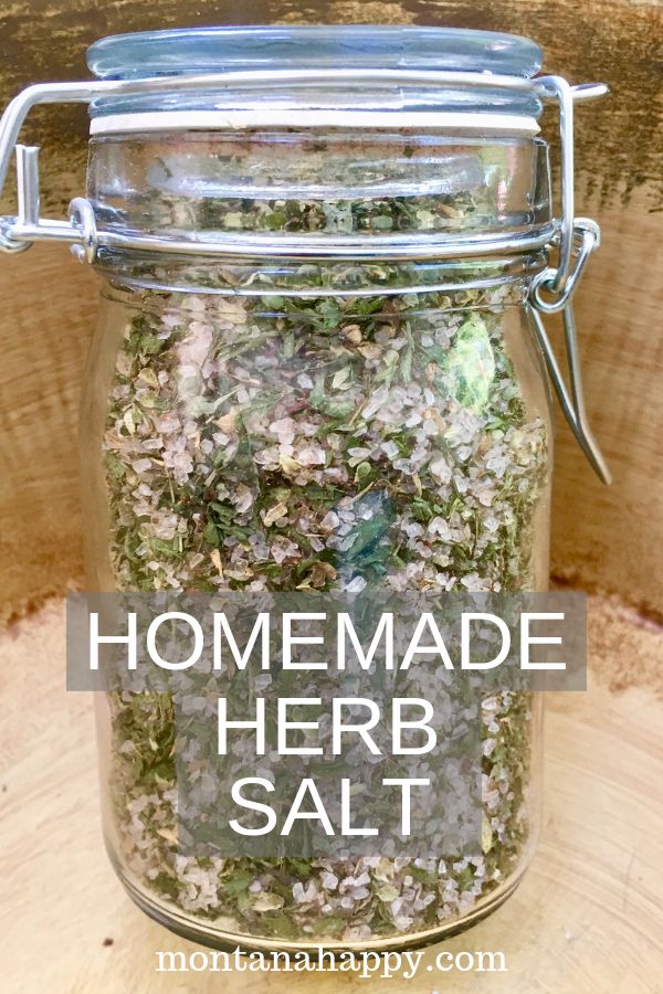 homemade herb salt in a glass jar with the words homemade herb salt above it on a wood background