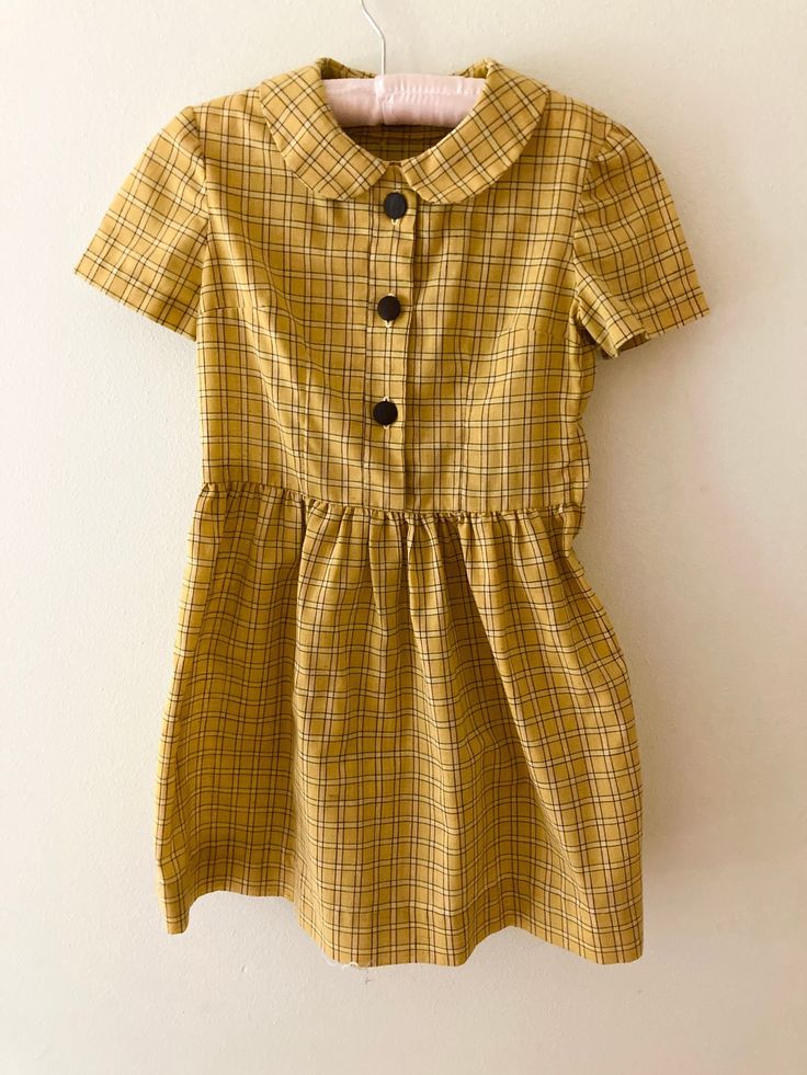 "Absolutely perfect cotton day dress with Peter Pan collar. It is so sweet on; Rumpus Room is sad to see it go! This beauty is handmade, but fits best for a modern size 5 or 6.  Measures: 13\" at chest 12\" at waist 26\" in length In excellent vintage condition, with no rips, stains, tears, holes, or other defects.  A true gem!" Spring School Dress With Collar, Collared Spring Dresses For School, Fitted Doll Collar Dress For School, Retro Cotton Vintage Dress For Daywear, Casual Cotton Dress With Peter Pan Collar, Spring School Dresses With Buttons, Retro Cotton Plaid Dress, Retro Plaid Cotton Dress, 1950s Cotton Vintage Dress For Daywear