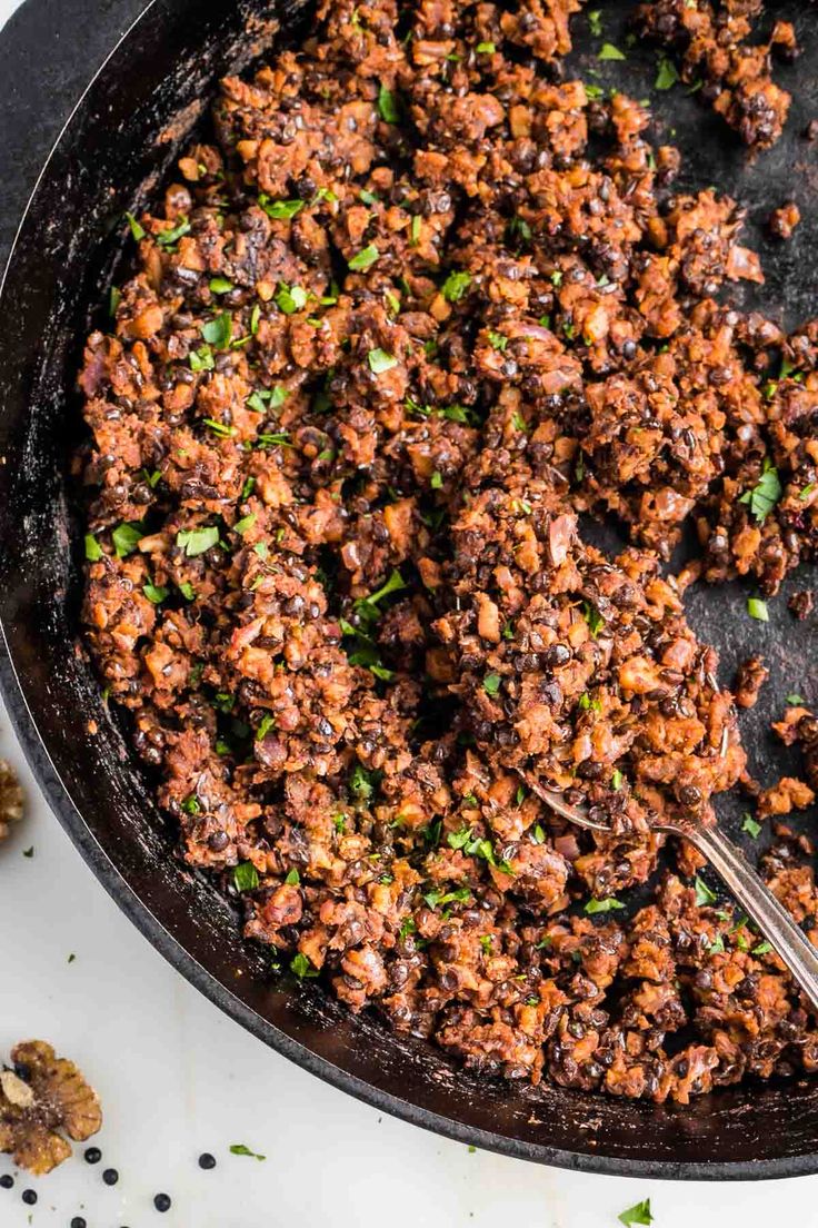 a skillet filled with ground beef and garnished with parsley