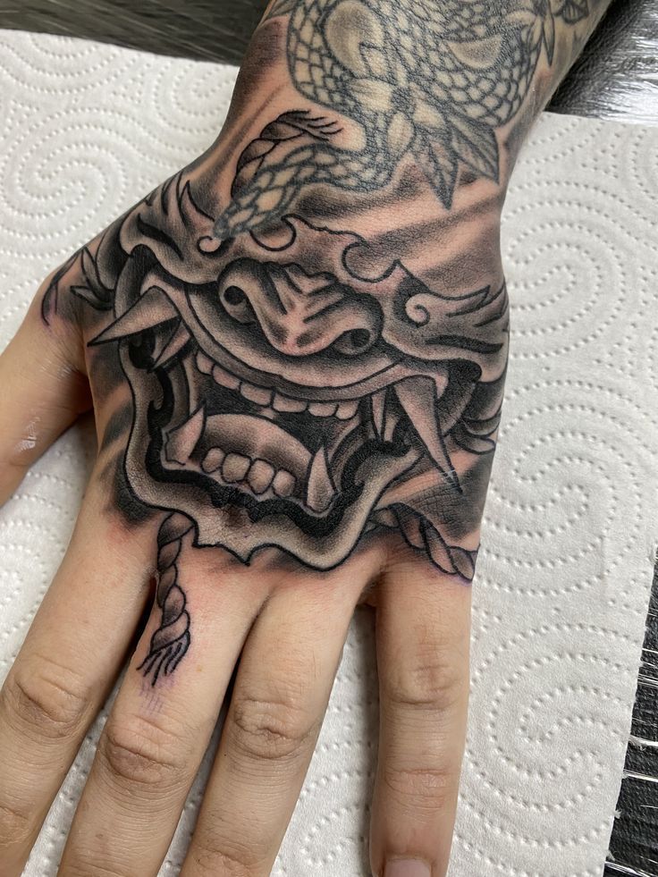 a person's hand with a tattoo on it and a dragon in the middle