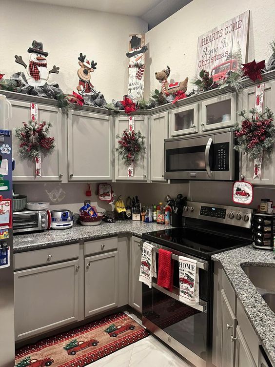 the kitchen is decorated for christmas with holiday decorations on the cabinets and counter tops, along with other decor