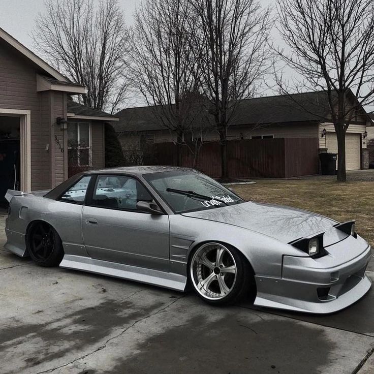 a silver car parked in front of a house