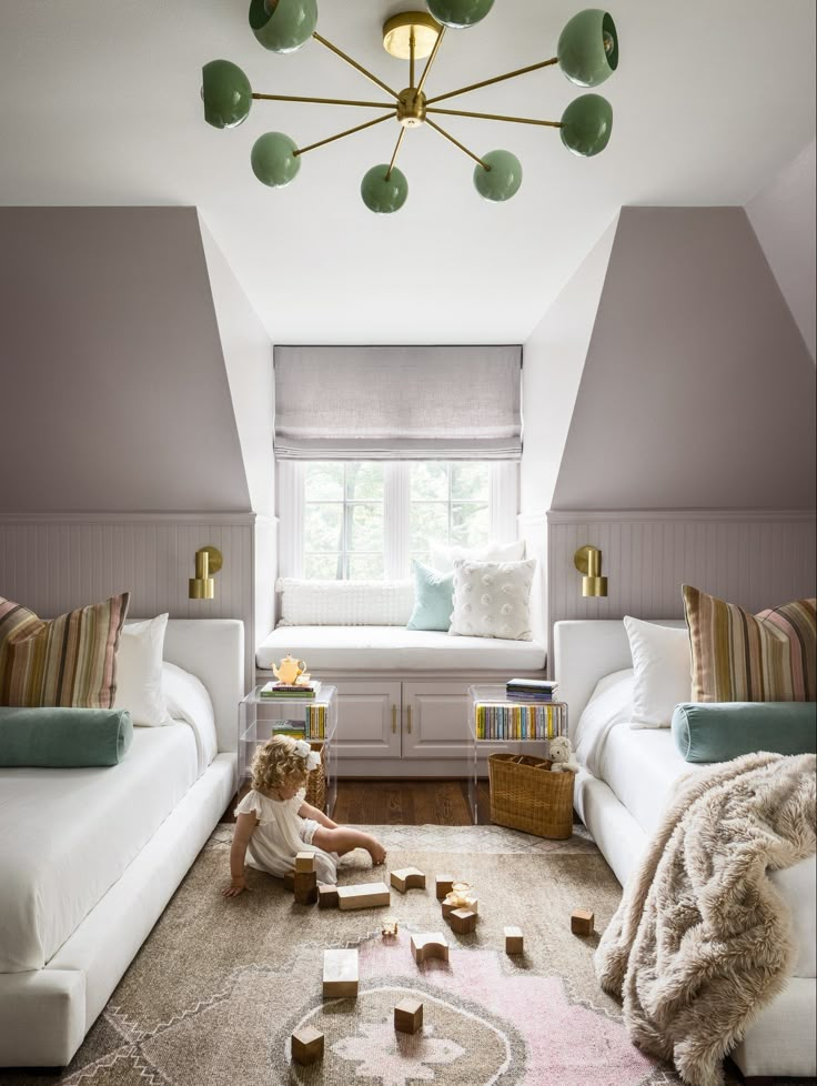 a child's room with two white couches and a pink rug on the floor